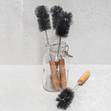 black bristle bottle brush with twisted wire stem and wooden handle displayed in glass ball jar