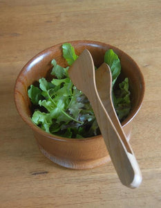 SIMPLE WOODEN bowl of salad greens with cherry wood salad tongs perched on top