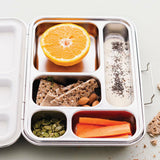 nestling bento lunch box stainless steel with 5 compartments, showing carrots, pumpkin seeds, rye crackers and almonds, half an orange, yoghurt with chia seeds